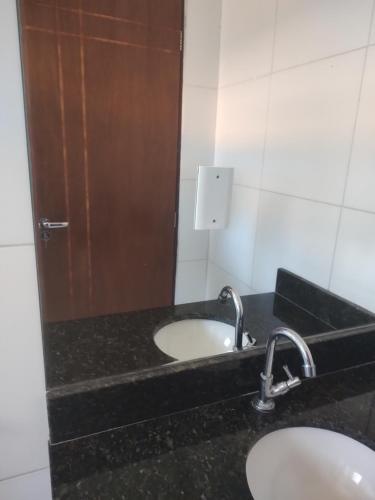 W łazience znajduje się umywalka i lustro. w obiekcie Hostel da Prainha w mieście Marechal Deodoro
