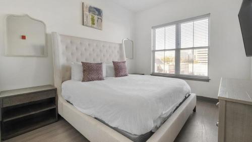 een witte slaapkamer met een groot bed en een raam bij Landing Modern Apartment with Amazing Amenities (ID1400X813) in Birmingham