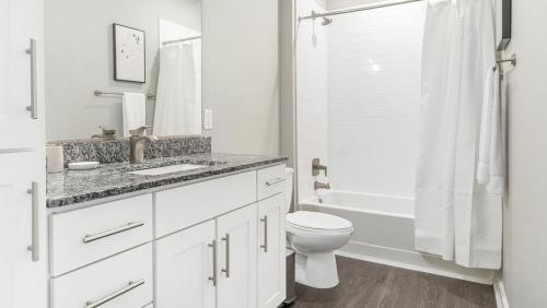 Baño blanco con lavabo y aseo en Landing Modern Apartment with Amazing Amenities ID1234X280 en Chapel Hill