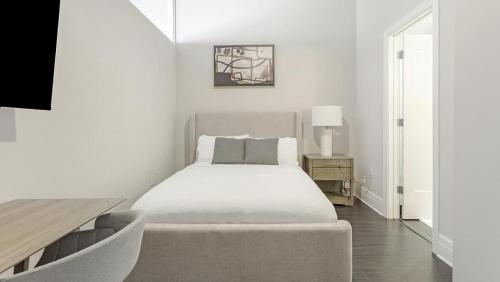 a white bedroom with a bed and a table at Landing - Modern Apartment with Amazing Amenities (ID7691X05) in Richmond