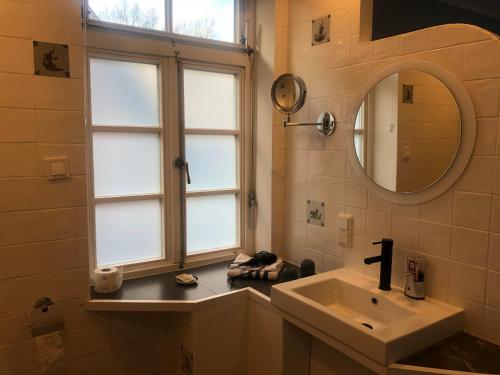 baño con lavabo, espejo y ventana en Bruchmühlen, en Bruchhausen-Vilsen