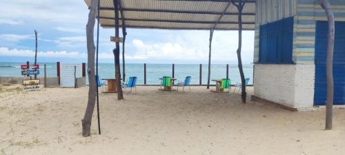een strand met stoelen en een gebouw op het strand bij Casa Praia de Tabatinga in Nísia Floresta