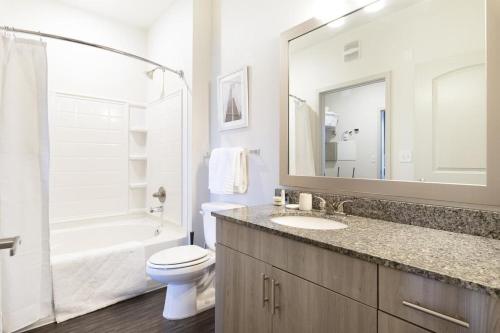 a bathroom with a sink and a toilet and a tub at Landing Modern Apartment with Amazing Amenities ID8348X93 in Kansas City