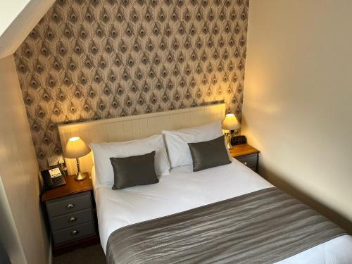 a bedroom with a bed with two nightstands and two lamps at Best Western Valley Hotel in Ironbridge