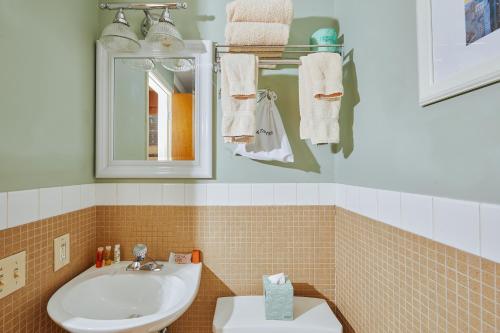 bagno con lavandino, specchio e asciugamani di Alexander Inn a Philadelphia