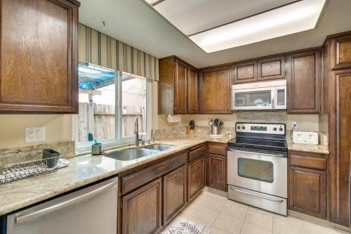 a kitchen with wooden cabinets and a stove top oven at Sun-Kissed Orangevale Home with Private Hot Tub! in Orangevale