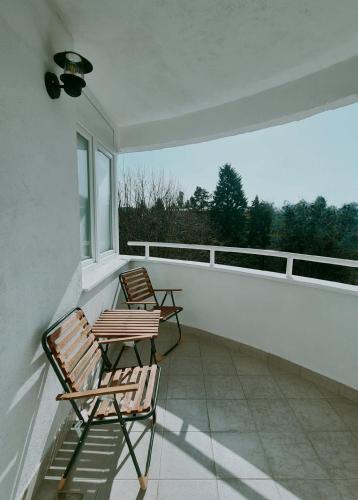 two chairs on a balcony with a view of trees at Apartment Rea in Čapljina