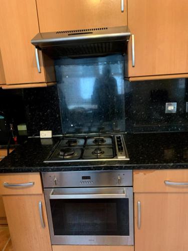 a stove top oven in a kitchen with granite counter tops at 3 Bedroom Apartment, Flat in London in Forest Hill