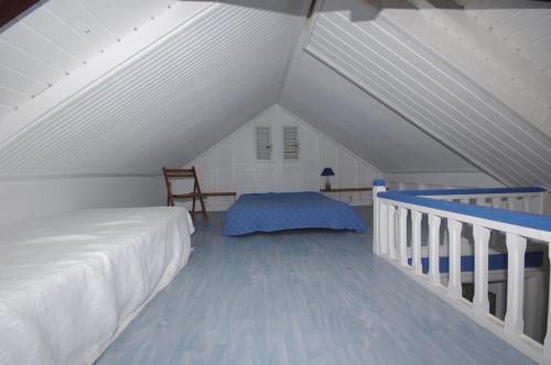 a attic bedroom with a bed and a staircase at Gite le colibri Bungalow Azur avec réserve d'eau in Saint-François