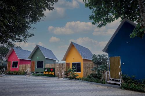 a row of houses painted in different colors at Konfudha Resort in Kalpetta