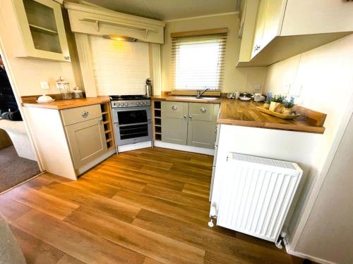 a kitchen with wooden floors and a stove top oven at Idyllic mobile home in beautiful surroundings in Porchfield