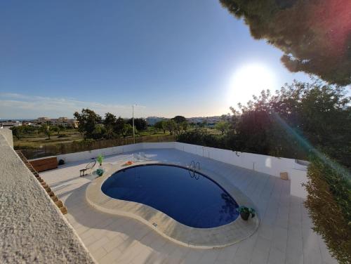 a large swimming pool on a patio next to a fence at VILLAMOR in Albufeira