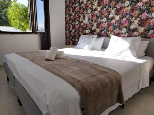 a bedroom with a large bed with a floral wall at VILLAMOR in Albufeira