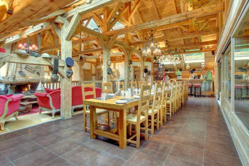 una sala da pranzo con un lungo tavolo e sedie di La Ferme du Lac Vert a Montriond