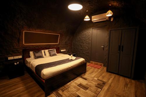 a bedroom with a bed and a tv on the wall at Konfudha Resort in Kalpetta