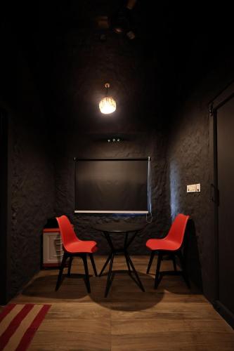 two chairs and a table in a room with a tv at Konfudha Resort in Kalpetta