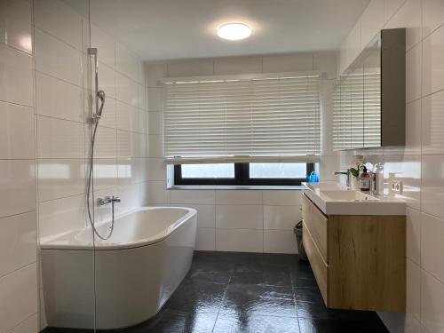Luxe Appartement Marc في آرنم: حمام أبيض مع حوض ومغسلة