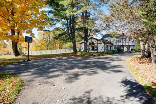 uma estrada com árvores e uma casa ao fundo em Lake and Vineyard Views Country Home with Spa! em Warren
