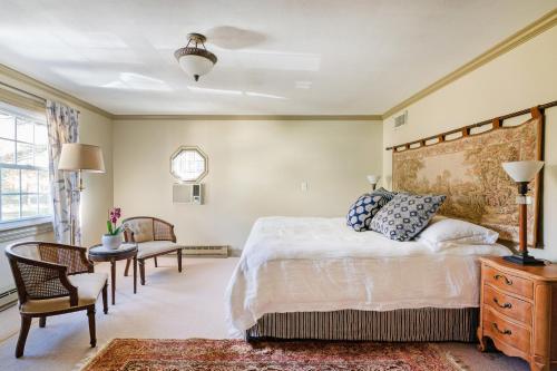ein Schlafzimmer mit einem großen Bett und einem Stuhl in der Unterkunft Lake and Vineyard Views Country Home with Spa! in Warren