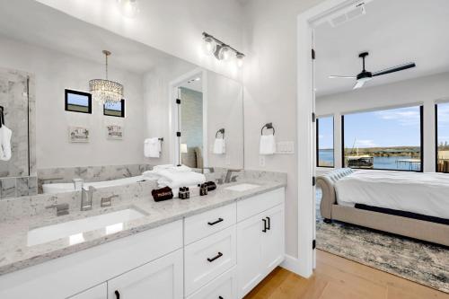een witte badkamer met 2 wastafels en een grote spiegel bij Captain's Cove Retreat New Listing Concierge Services in Horseshoe Bay