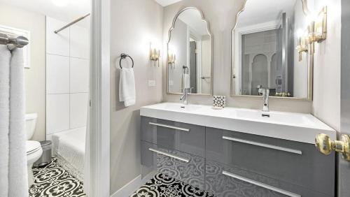La salle de bains blanche est pourvue d'un lavabo et d'un miroir. dans l'établissement Landing - Modern Apartment with Amazing Amenities (ID3736X50), à Denver