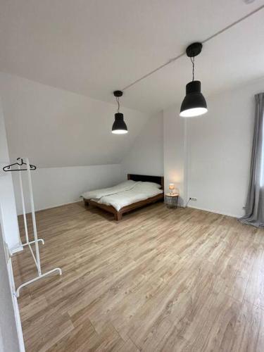 Habitación blanca con cama y suelo de madera. en Wohnung, 2 Schlafz. 4 Pers., en Siegen