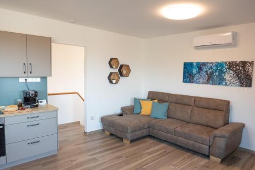 a living room with a couch and a kitchen at Lila akác vendégház in Keszü