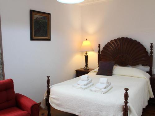 ポンテ・デ・リマにあるNice Cottage in Santa Comba with Communal Poolのベッドルーム1室(ベッド1台、赤い椅子付)