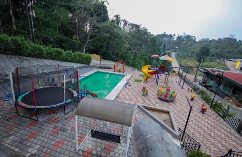an outdoor playground with a pool and a slide at Konfudha Resort in Kalpetta
