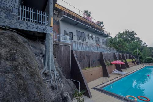 a hotel with a swimming pool next to a building at Konfudha Resort in Kalpetta