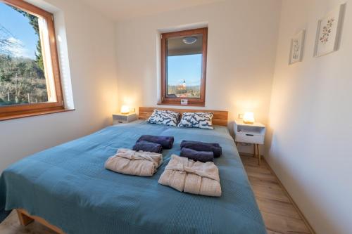 a bedroom with a large blue bed with two pillows at Lila akác vendégház in Keszü