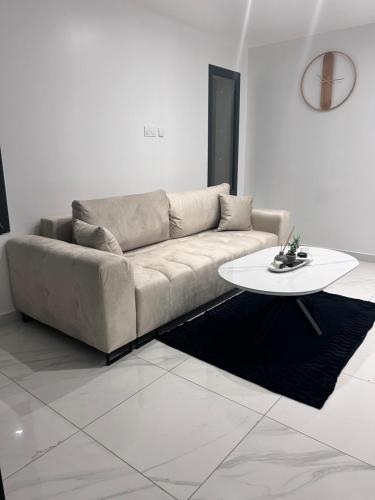 un salon avec un canapé et une table dans l'établissement Appartement + piscine et extérieur, à Rivesaltes