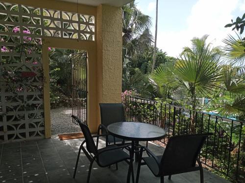 a patio with a table and chairs on a balcony at Juliette - Studio, Sunset ocean views, pool. in Cruz Bay