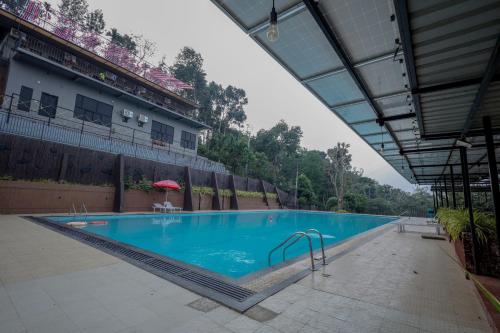 a large swimming pool in the middle of a building at Konfudha Resort in Kalpetta