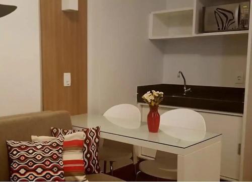 a table with two chairs and a vase with flowers on it at S4 HOTEL: Flat Lindo, Aconhegante e bem localizado in Brasilia