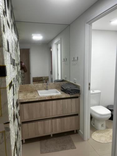 uma casa de banho com um lavatório e um WC em Apartamento no centro em Foz do Iguaçu