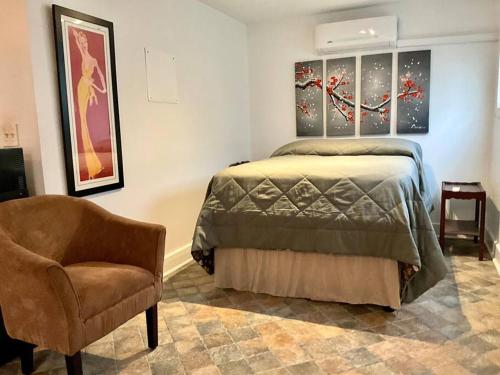 a bedroom with a bed and a chair at Charming Studio in the Heart of Springfield in Jacksonville