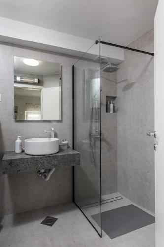 a bathroom with a glass shower and a sink at Dubrovnik Domus Apartment in Dubrovnik
