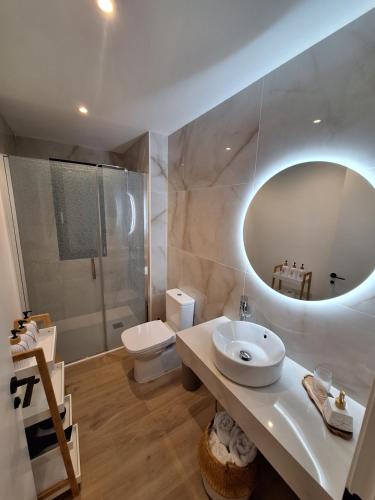 ein Badezimmer mit einem Waschbecken, einem WC und einem Spiegel in der Unterkunft Aromas del Jiloca, Tierra de Trufas in Calamocha