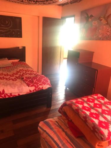 1 dormitorio con 2 camas y mesa con lámpara en Casa Tola, en Quito
