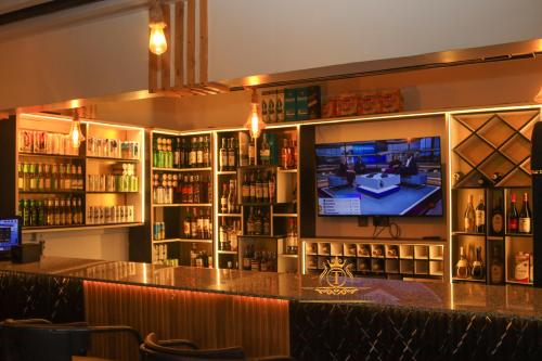 a bar with a flat screen tv in a room at TAWALA GARDEN HOTEL in Nairobi