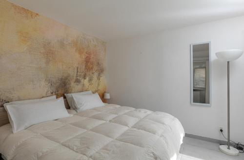 a bed in a white room with a wall at Dubrovnik Domus Apartment in Dubrovnik