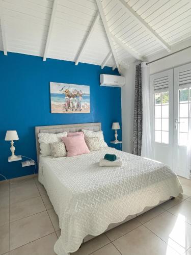 - une chambre avec un grand lit et un mur bleu dans l'établissement Résidence Subtropicale, à Saint-François