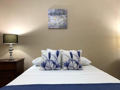 a bedroom with a bed with blue and white pillows at Posada Florencia AC near Guanacaste Airport in Liberia