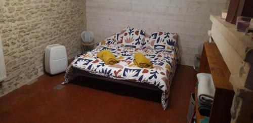 une chambre avec un lit avec des oreillers jaunes dessus dans l'établissement Logement en pierres apparentes avec terrasse privative, à Giberville