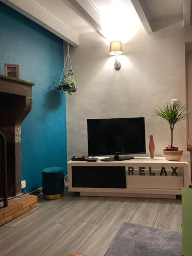 a living room with a flat screen tv on a table at Maison toute équipée Gerzat in Gerzat