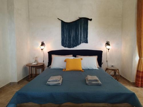 ein Bett mit einer blauen Decke und zwei Handtüchern darauf in der Unterkunft PAPs Farm - Alexandria Double Apartment in Gavrio