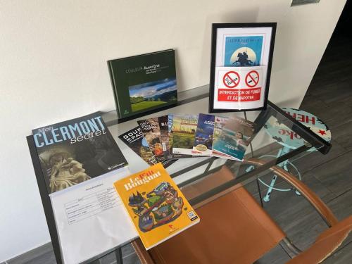 a glass table with some books on top of it at Maison toute équipée Gerzat in Gerzat