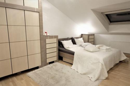 - une chambre avec un lit doté de draps et d'oreillers blancs dans l'établissement Old Town Luxury and Spacious Apartment (155 m2). 3 bedrooms. FREE parking, à Vilnius