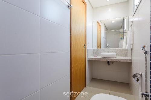 MuquiçabaにあるLindo apto a apenas 400m da Praia do Morro CVE402の洗面台と鏡のあるバスルーム